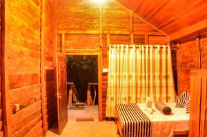 a room with a bed in a wooden house at Green Garden Resort in Habarana