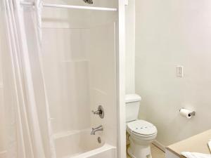 a white bathroom with a shower and a toilet at White Caps Motel in North Wildwood