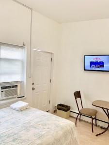 a bedroom with a bed and a table and a tv at White Caps Motel in North Wildwood