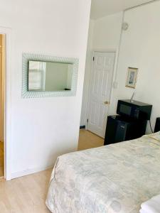 1 dormitorio con cama y espejo en la pared en White Caps Motel, en North Wildwood