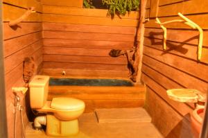 - une salle de bains avec toilettes dans un sauna en bois dans l'établissement Green Garden Resort, à Habarana