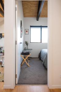 een open deur naar een slaapkamer met een bed en een tafel bij Manaia Studio in Tairua
