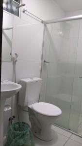 La salle de bains est pourvue de toilettes et d'une douche en verre. dans l'établissement Pousada Bela Vista, à Guabiraba