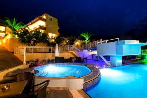 a swimming pool in a resort at night at Hotel Diamond in Limenaria