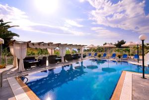 a large swimming pool with chairs and umbrellas at Hotel Diamond in Limenaria