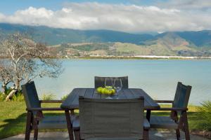 a table with a bowl of fruit and wine glasses at Monaco Waterside Magic in Nelson