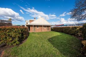 a brick house with a lawn in front of it at Peppertree Terraces in Mudgee