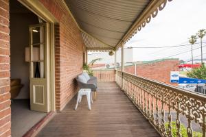a balcony with a chair and a table at Peppertree Terraces in Mudgee