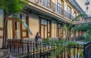 a man walking in front of a building with plants at Up Tribeca in Buenos Aires