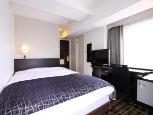 a hotel room with a bed and a desk at APA Hotel Shimbashi Onarimon in Tokyo