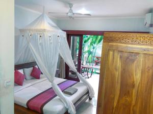 um quarto com uma cama de dossel em Umah Belos em Ubud