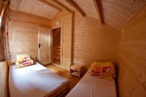 a small room with two beds in a wooden cabin at OW Gabi in Międzywodzie