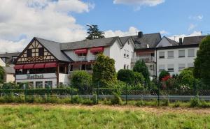 ein Gebäude mit einem Zaun davor in der Unterkunft Hotel Rebstock in Bruttig-Fankel