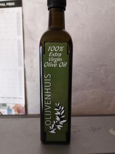 una bottiglia di olio d'oliva seduta su un tavolo di Kalamata a Beaufort West