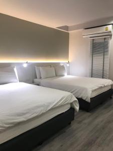 um quarto de hotel com duas camas e uma janela em Urban house em Bangkok