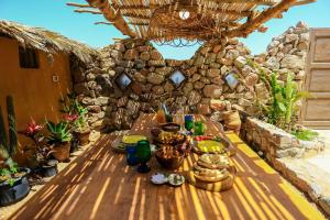 drewniany stół z jedzeniem na kamiennej ścianie w obiekcie Beit Theresa w mieście Dahab