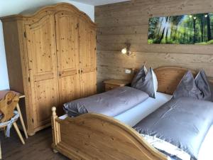 1 dormitorio con 2 camas y pared de madera en Haus Straif, en Brixen im Thale
