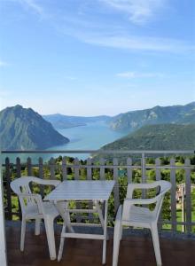 a table and chairs on a balcony overlooking a lake at Panorama Verde Lago - Mountain Lake Iseo Hospitality in Bossico
