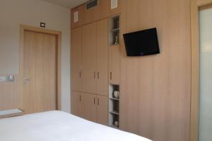 a bedroom with a bed and a tv on a wall at Albergo Nicolin in Lecco