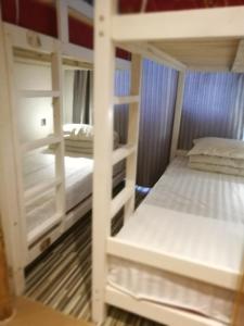 2 beliches brancos num quarto com em Right Here Hotel (Dunhuang International Youth Hostel) em Dunhuang