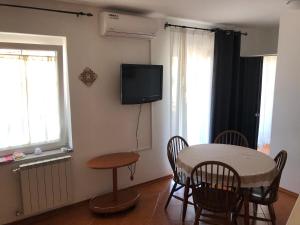 um quarto com uma mesa e cadeiras e uma televisão em Arcobaleno isolano em Izola