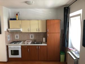 a small kitchen with wooden cabinets and a stove at Arcobaleno isolano in Izola
