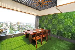 a dining room with a table and a green wall at Theory9 Premium Service Apartments Khar in Mumbai