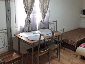 um pequeno quarto com uma mesa e cadeiras e uma cama em Melanie apartman em Veľký Meder