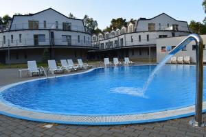 uma piscina com uma fonte de água no meio em Apartament Silence Baltic Róża Wiatrów em Pobierowo