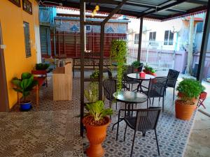 a patio with tables and chairs and potted plants at Siri Guesthouse in Phra Nakhon Si Ayutthaya