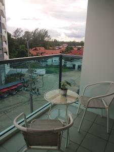 einen Balkon mit einem Tisch und Stühlen sowie Blick auf einen Parkplatz in der Unterkunft Grandblue 411 in Mae Pim