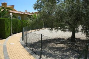 una recinzione con un albero in mezzo a un vialetto di villa (3 bed and 2 bath) in the Oliva Nova Golf&Beach resort a Oliva