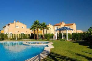 a large swimming pool in front of a house at villa (3 bed and 2 bath) in the Oliva Nova Golf&Beach resort in Oliva