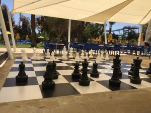 a giant chessboard on a patio with tables and chairs at Papouis Protaras Hotel in Protaras +63 photos