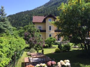 una casa en medio de un patio con un banco en Villa Talheim, en Mallnitz