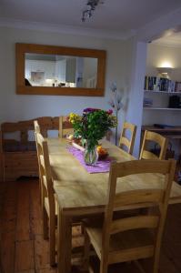 a dining room table with a vase of flowers on it at The Old Quayside House in Falmouth +35 photos