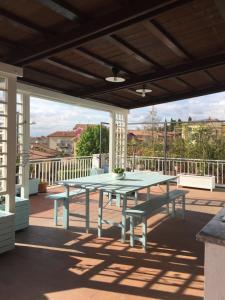 a patio with a table and benches on a deck at la casa di Ale in Manciano