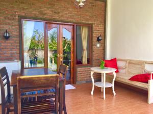 a living room with a dining room table and a couch at Villa Dika Pemuteran in Pemuteran