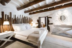 a bedroom with a white bed and a white desk at Monastery Estate Guesthouse in Sougia