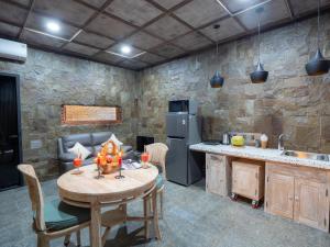 a kitchen with a wooden table and a stone wall at Octopus Villas in Tejakula