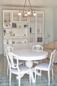 a white dining room with a white table and chairs at Villa Maria Antonietta in Vietri sul Mare