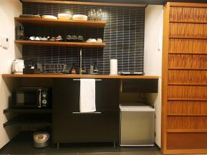 a kitchen with a counter with a microwave and a shelf at 曼 东福寺之 壹 in Kyoto