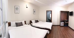 Postel nebo postele na pokoji v ubytování Le Grey Dalat Hotel