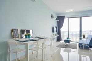 a white kitchen with a dining table and chairs at Miko's Studio @ Setia alam in Shah Alam