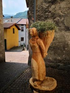 una estatua de una mujer sosteniendo una maceta en Residenza Se son Rose, en Schignano