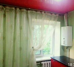 a room with a window with curtains and a table at Комфортні апартаменти з великим ліжком на Кірова ,поруч 16 лікарня,Дафі in Dnipro