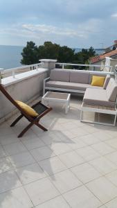 a patio with a couch and a chair on a roof at Apartments Lucija in Zadar