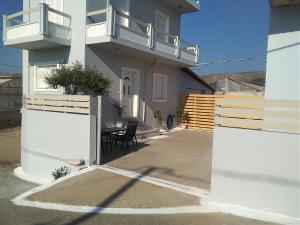 a white house with a table and a balcony at Sea Side House Rapanas in Falasarna