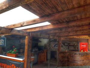 a kitchen with wooden walls and a ceiling with beams at Pensiunea Faast in Predeal