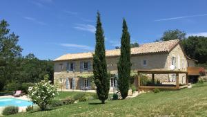 a large stone house with a pool and trees at Chambres d'Hôtes Le Val de la Garenne in Senouillac